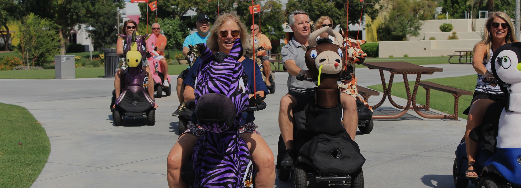 Adults enjoying a Tampa Rydables group tour on giant stuffed-animal scooters